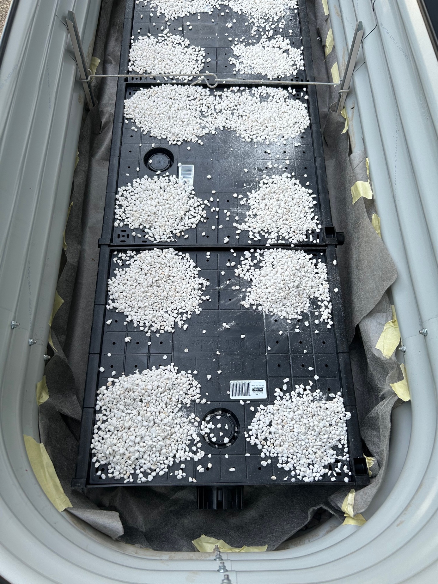 Wicking bed cells and perlite being installed inside a raised garden bed