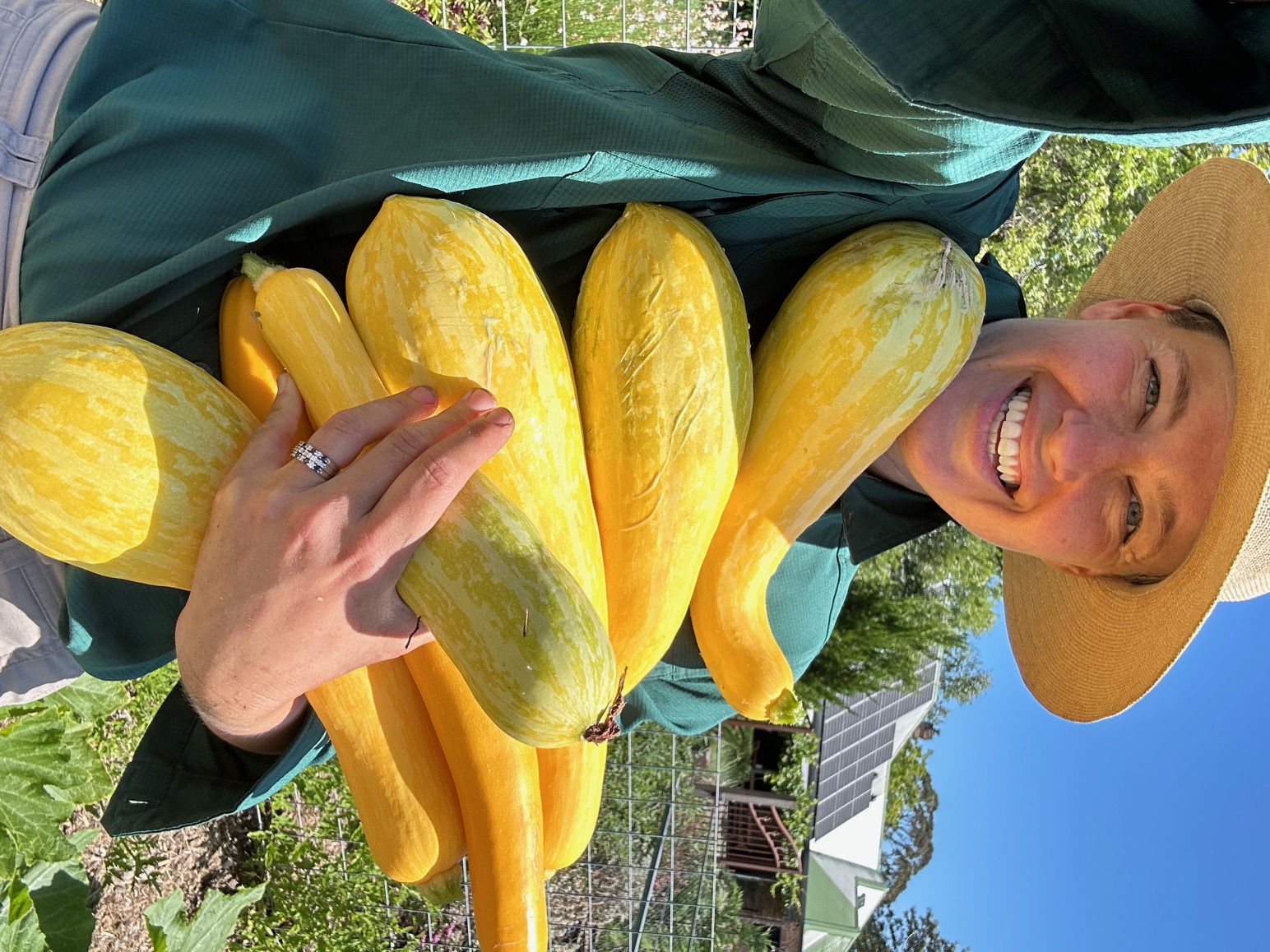 Portrait of the kitchen garden consultant holding an armful of homegrown zucchini